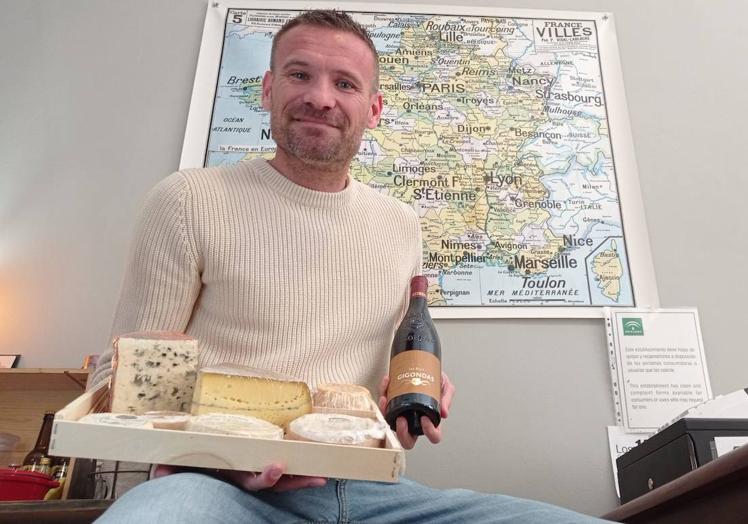 Una selección de queso y un vino para maridar bajo la atenta mirada del mapa con las ergiones de Francia de donde vienen los productos selecccionados