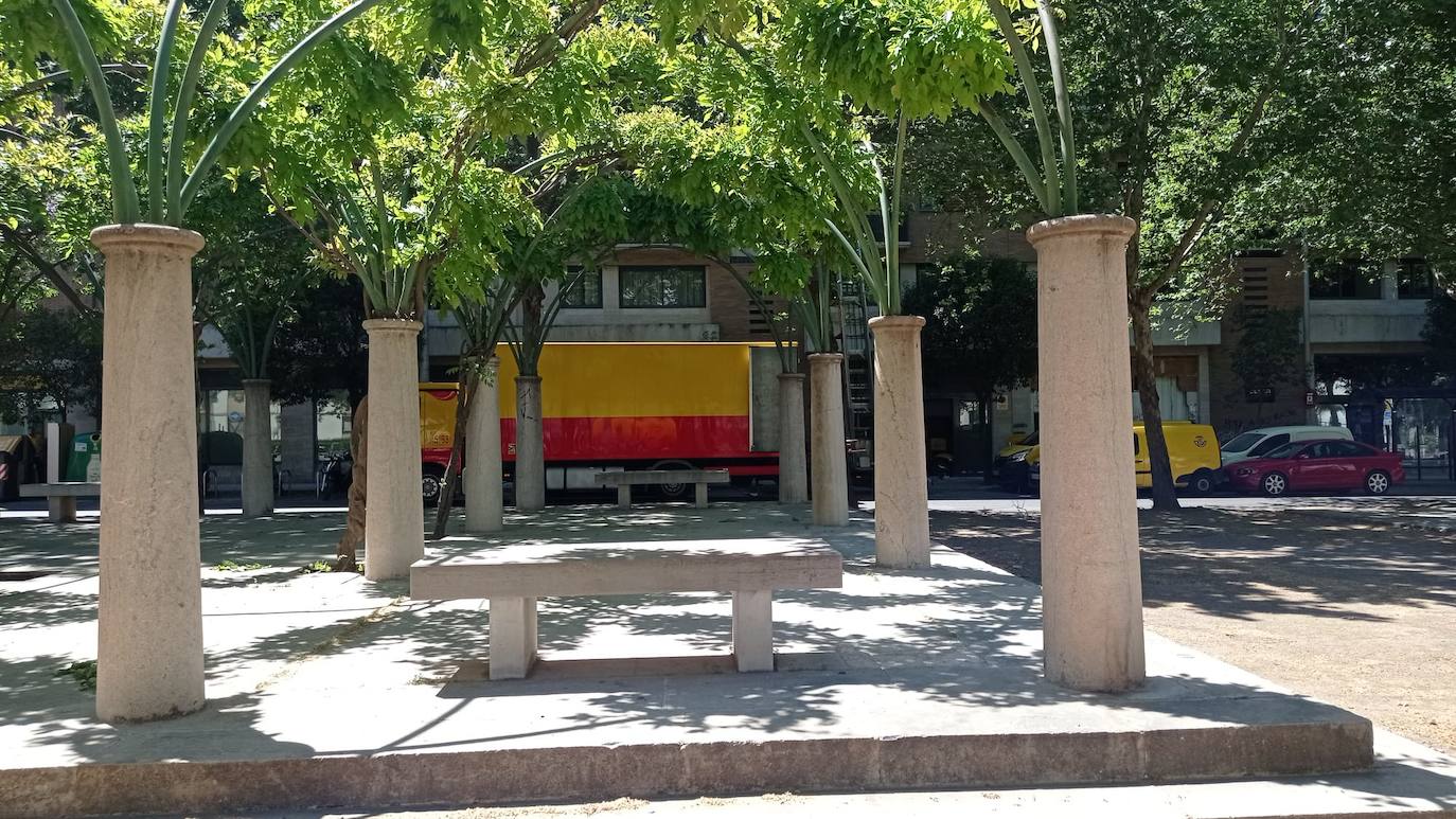 Columnas truncadas, un túnel verde y bancos de piedra sin respaldo, una vez más, bajo la sombra.