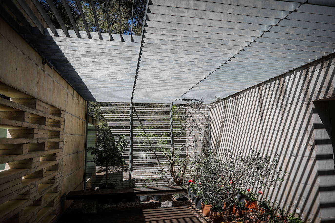 Las típicas rejas andaluzas se trasladan como celosías al techo de los patios para jugar con las sombras.