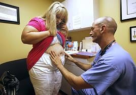 Cirujano bariátrico estudia a una paciente con obesidad.