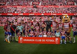 Los jugadores, en la foto de formación con unos pequeños.