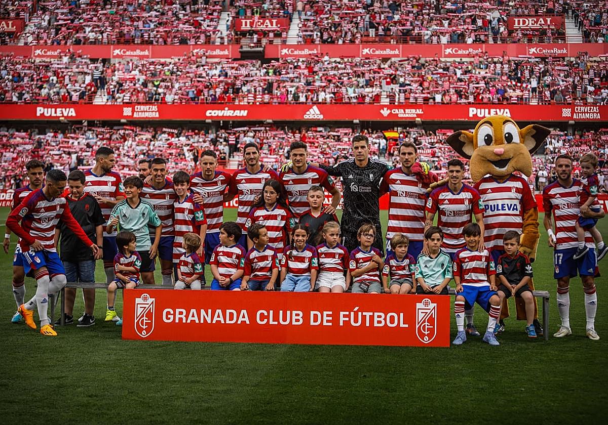 Los jugadores, en la foto de formación con unos pequeños.