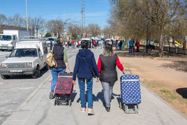 Clientes del mercadillo pasean por la calle Baden Powell.