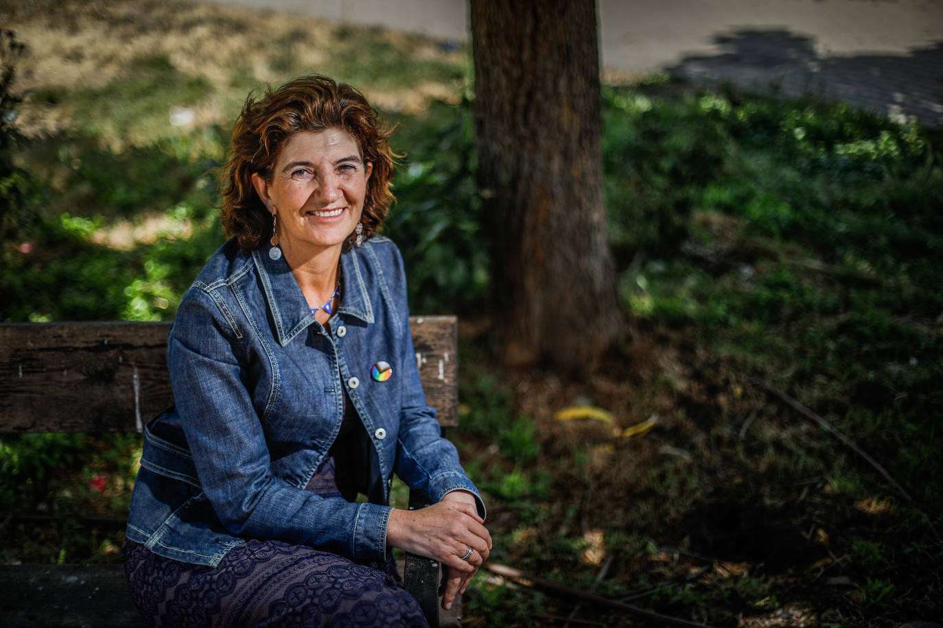 Elisa Cabrerizo, en un banco, con vegetación como telón de fondo.