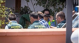 Guardias civiles conducen al detenido al interior de la vivienda para reconstruir el triple crimen.