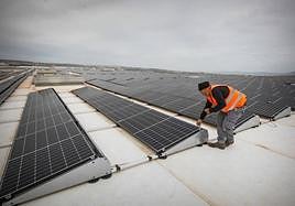 Un profesional revisando una instalación de placas solares en una industria granadina.