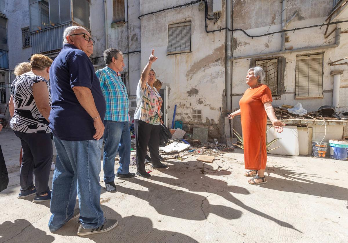 Varios vecinos de las zonas de Santa Adela 'olvidadas' charlan una mañana de junio en la zona común de un bloque sin rehabilitar.