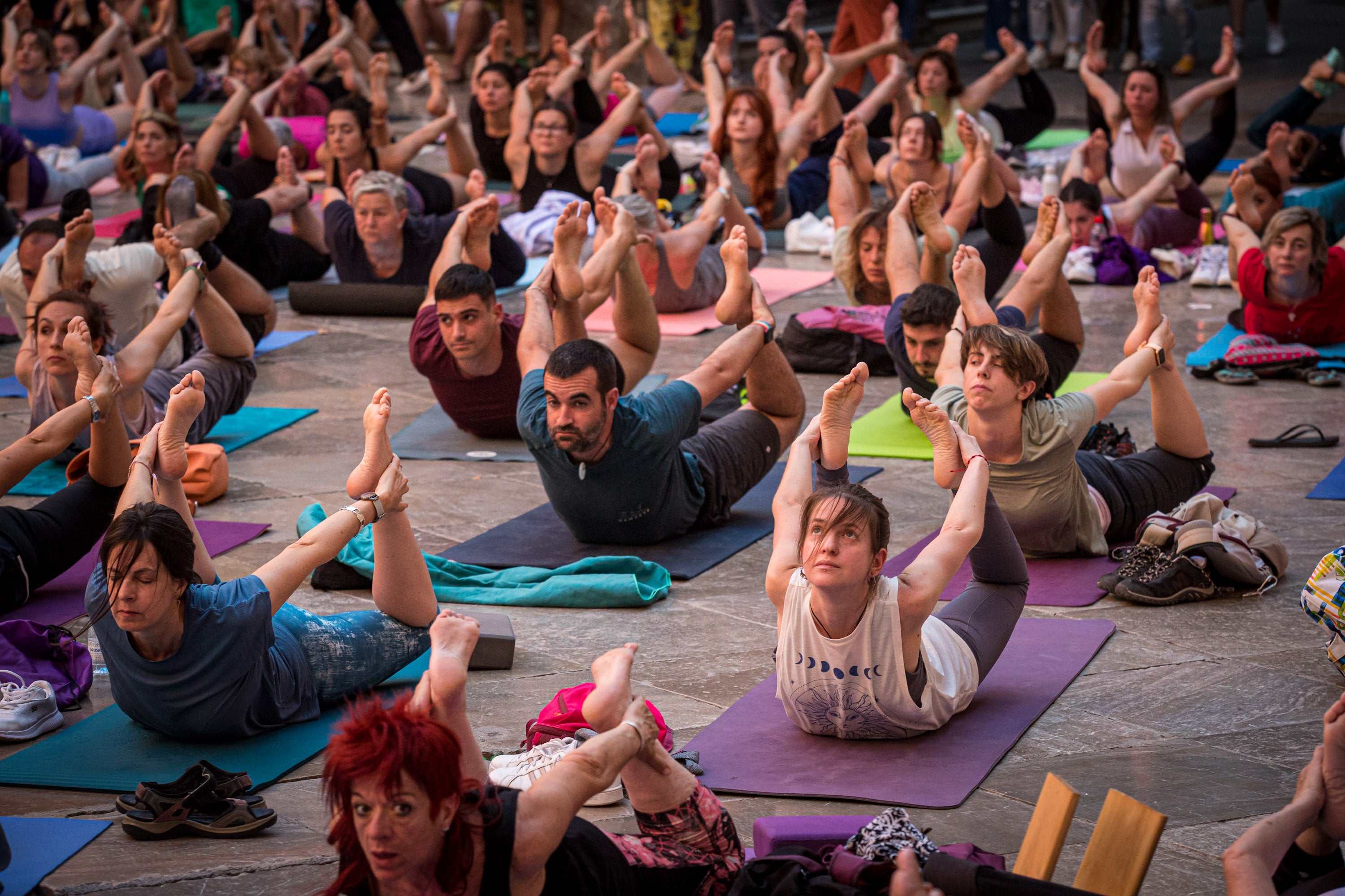 Praticantes de yoga hacen la postura del arco.