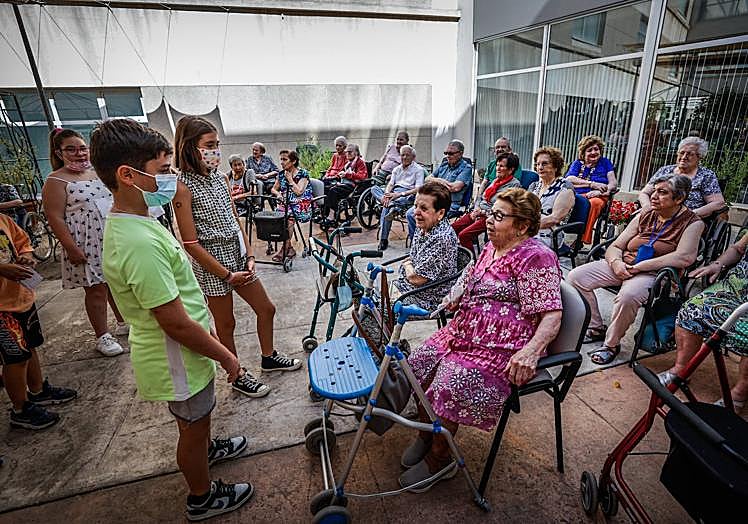 Varios de los menores saludan a los ancianos.