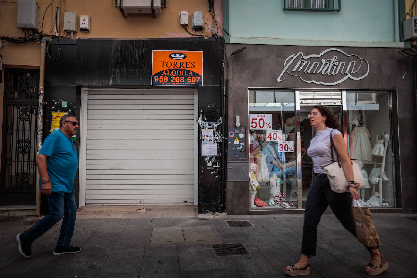 Imagen principal - Locales comerciales que se han quedado vacíos en el centro de Granada. 