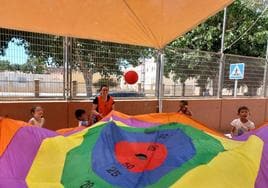 Una monitora de la Asociación 'El Saliente' con niños en una escuela de verano municipal.