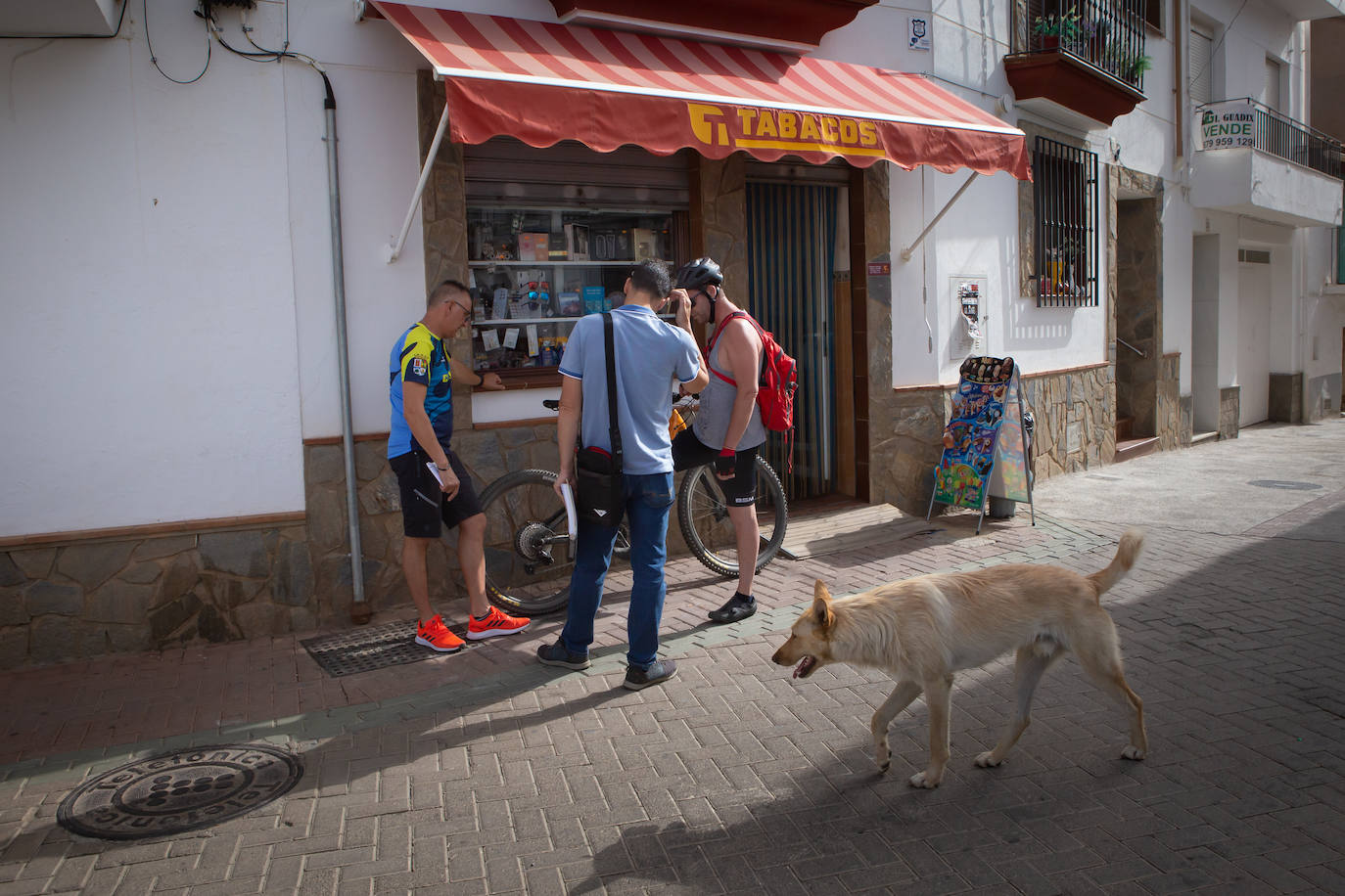 Imagen secundaria 1 - Arriba, ensayo en la casa de la cultura. Abajo, reunión delante del estanco e iglesia con el crucero peregrino en primer plano. 