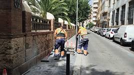 Dos empleados de mantenimiento trabajan en el acerado de la capital durante la mañana de ayer.