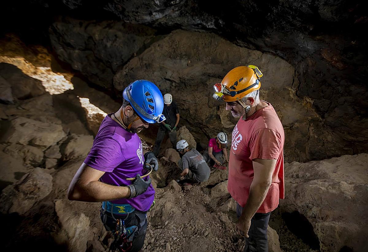 Francisco Martínez-Sevilla, director del proyecto Cueva de los Murciélagos, muestra una costilla de un niño a uno de sus colaboradores.