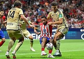 Memphis Depay trata de zafarse de Miguel Rubio e Ignasi Miquel.