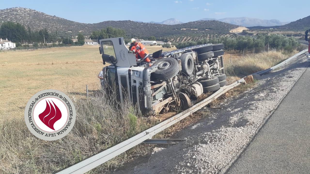 Un bombero del parque de Guadix inspeccionado el camión siniestrado.
