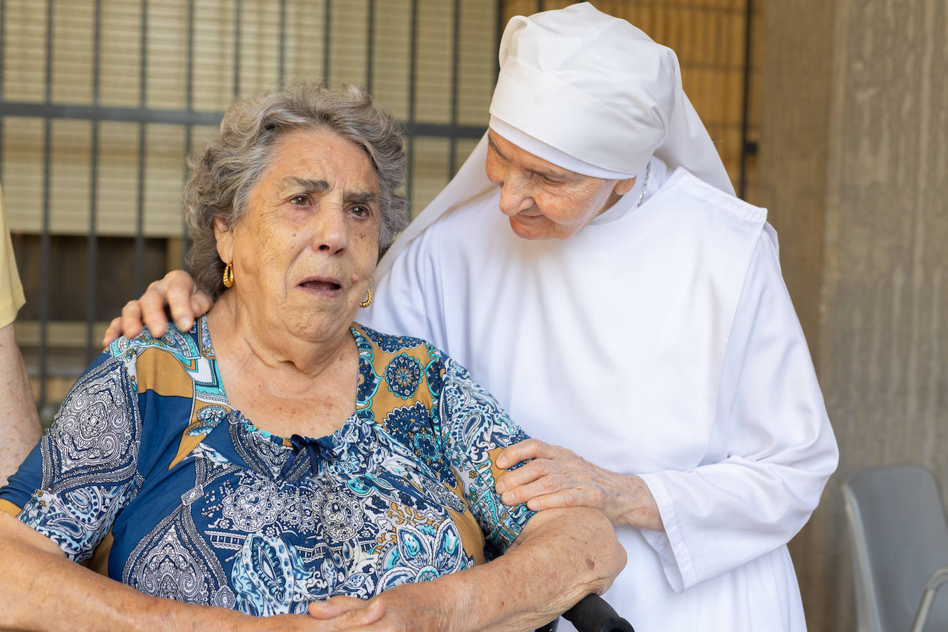 Imagen principal - SSor Adelina con una de las residentes a las que cuida, el grupo de hermanas y Pepe, otro de los residentes que ayuda en la cocina. 