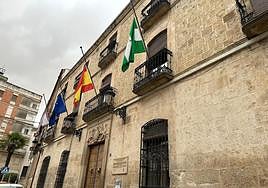 Fachada del Ayuntamiento de Villanueva del Arzobispo con las banderas a media asta.