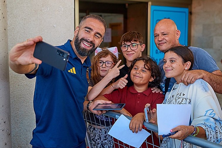 El jugador Dani Carvajal se fotografía con aficionados de la 'Roja' en Granada.