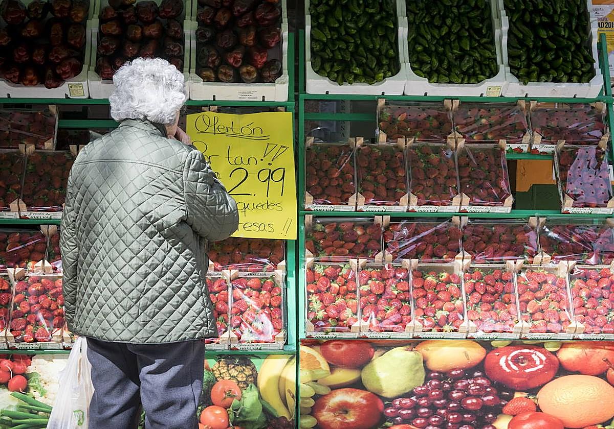 Una mujer mira precios en una frutería en una imagen de archivo.