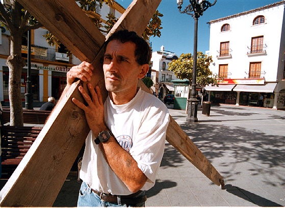 Justo portando una cruz a cuestas.
