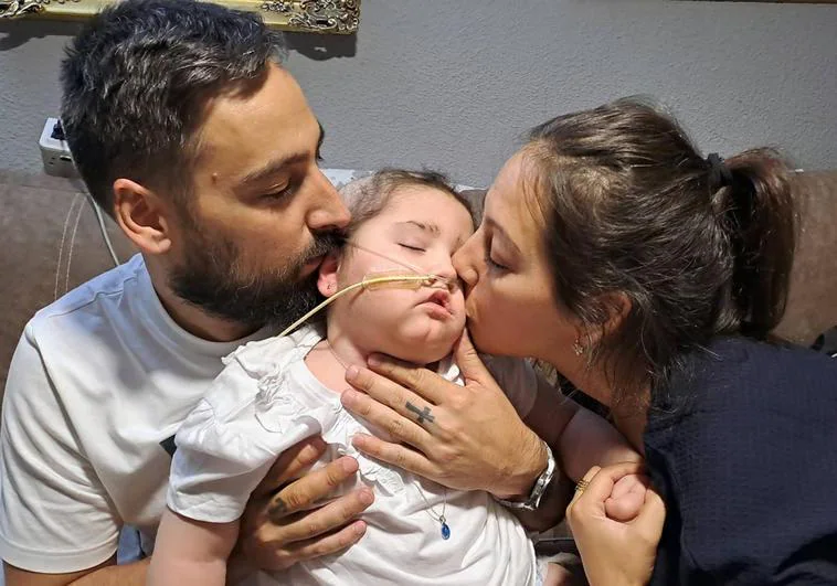Alba, pequeña de Peligros afectada por un tumor cerebral, con sus padres Raúl y María Victoria.