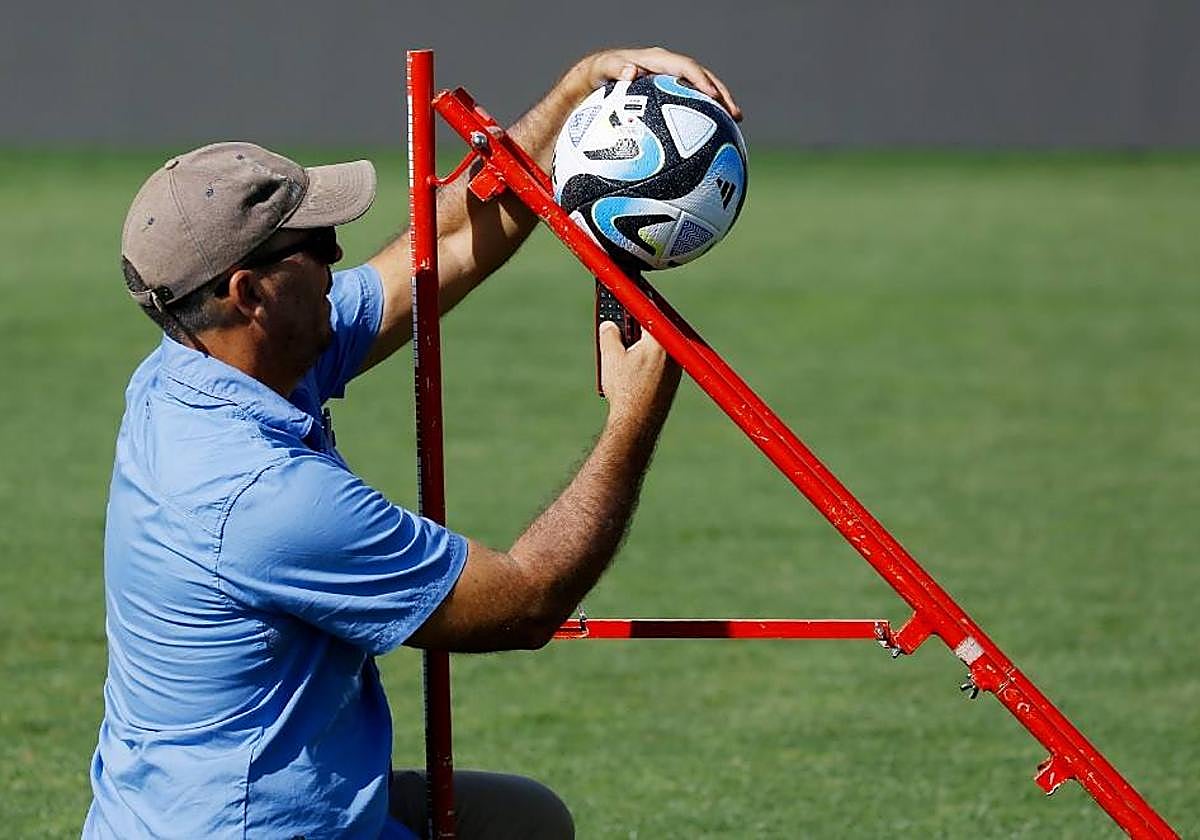 Un operario prueba un balón en la Ciudad Deportiva.