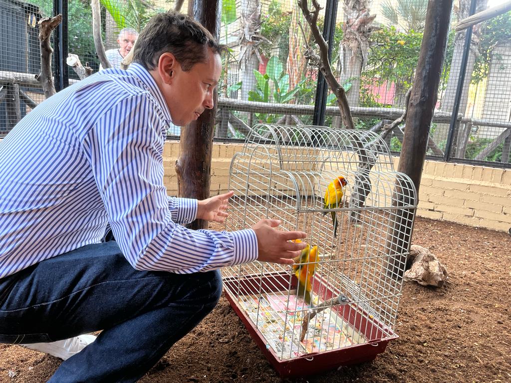 El edil Carlos Ferrón, junto a una pareja de loros.