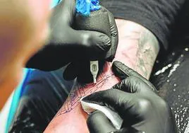 Un tatuador en pleno trabajo