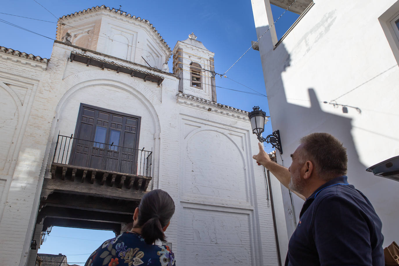 Imagen principal - Arriba, el alcalde de Santa Fe, Juan Cano, señala la grieta en la Puerta de Sevilla. Abajo, más grietas en la Puerta de Sevilla y en una vivienda del casco histórico santaferino. 