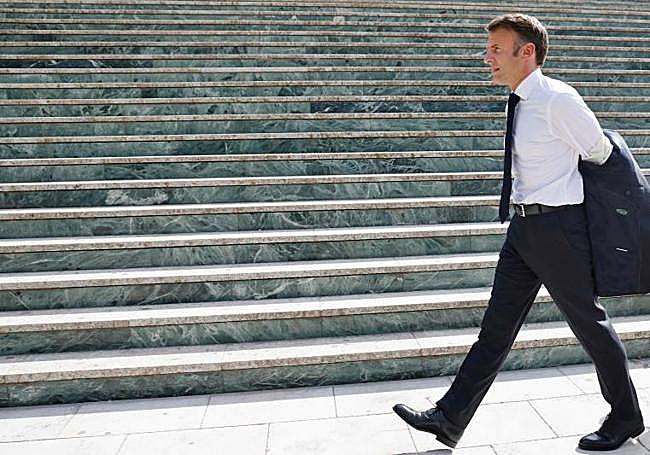 Macron se pone la chaqueta junto a las escaleras del Palacio de Congresos.