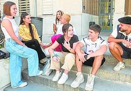 Ana y Lucía comparten risas y vivencias con sus compañeros y compañeras en la entrada de la Facultad de Trabajo Social.