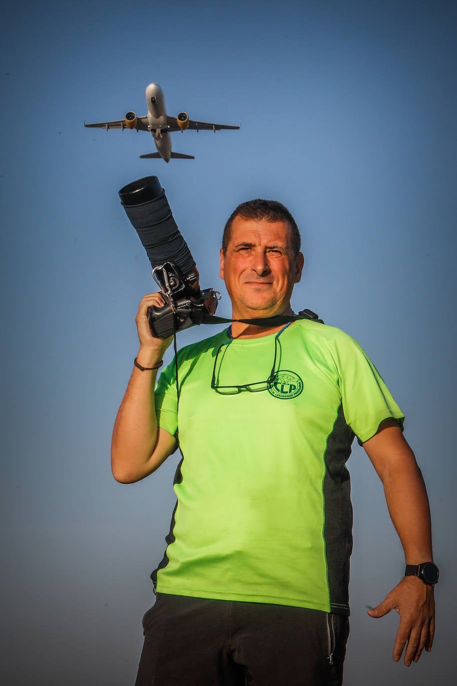 Ramón posa con su cámara mientras sobrevuela sobre su cabeza un vuelo con destino a Barcelona.
