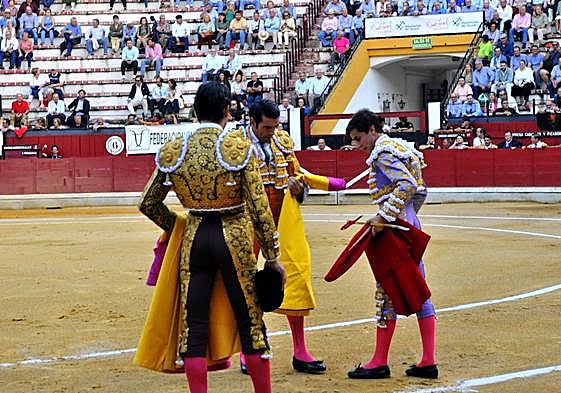 Marcos Linares recibe los trastos de torear de manos de Emilio de Justo, y Juan Ortega como testigo.