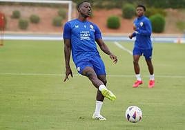 Dion Lopy golpea el balón, con Largie Ramazani al fondo.