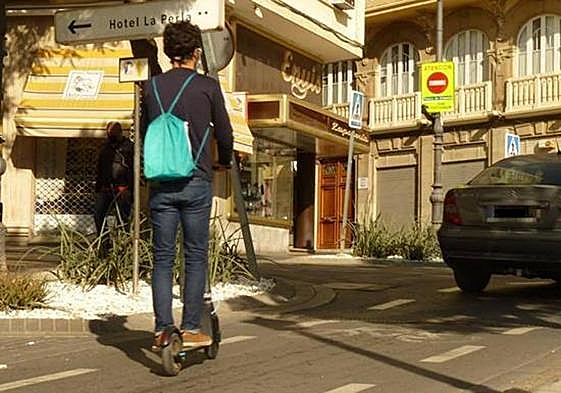 Un hombre circula en patinete eléctrico por el centro.