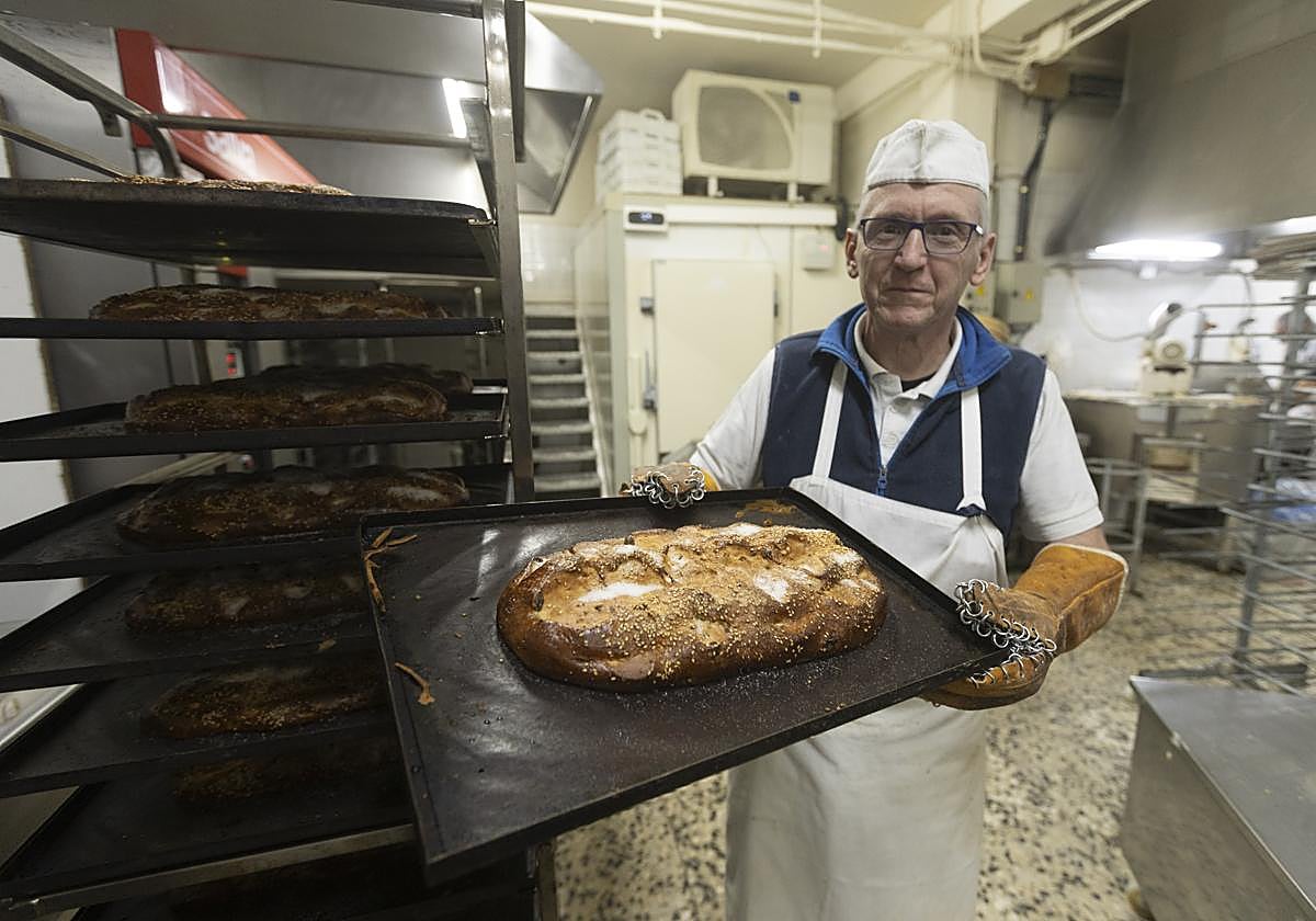 Antonio, nieto del 'Pasteles', saca del horno del obrador una remesa de nochebuenos.