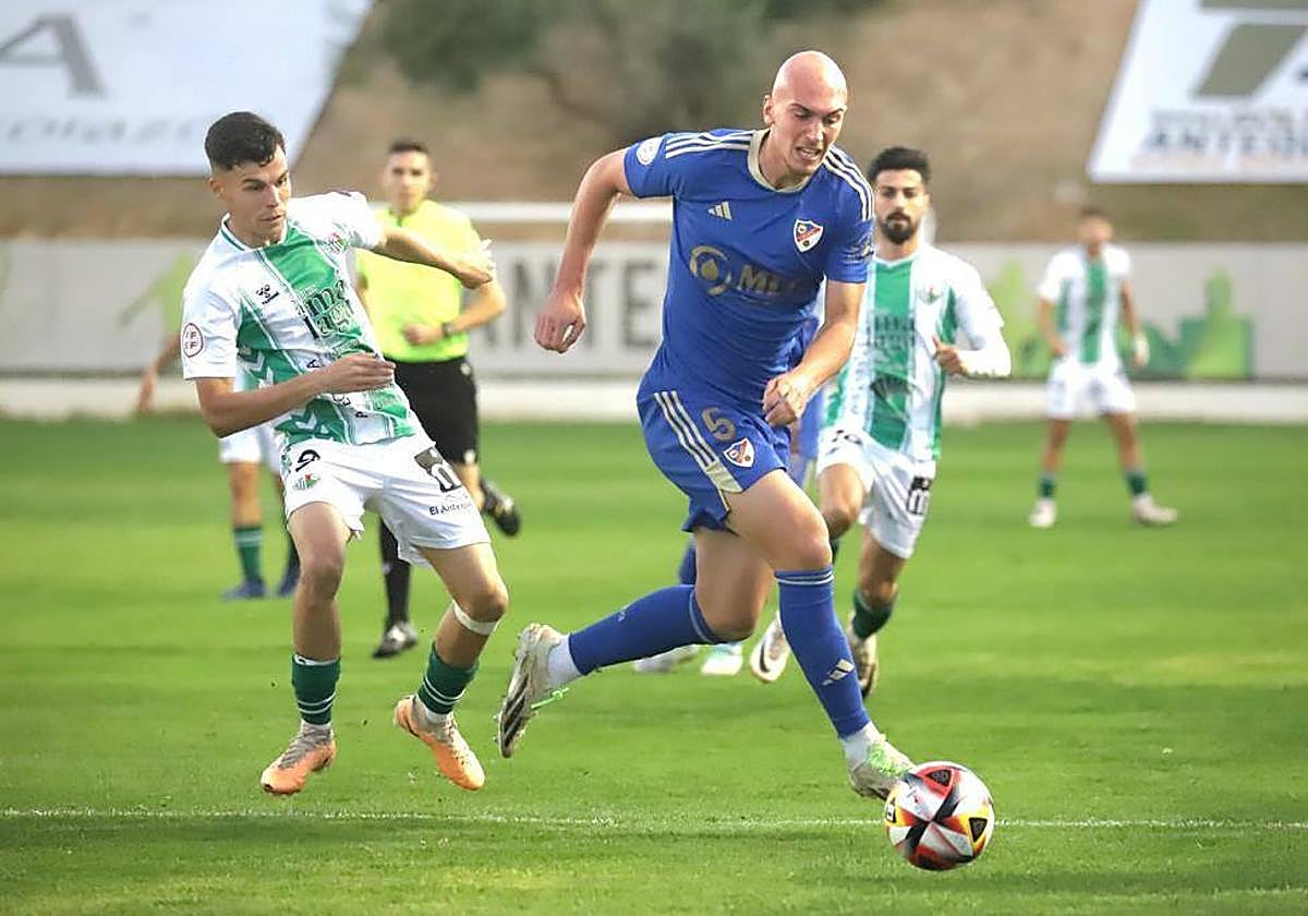 Rentero sacándole un balón desde la defensa al atacante antequerano Luismi Redondo.