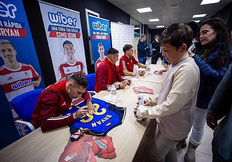 Los tres futbolistas, durante las firmas.
