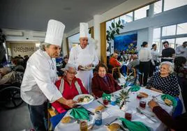 Los chefs Tony Parra y Miguel Ayala sirven los platos a los mayores de la residencia.