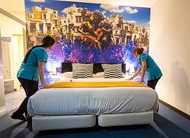 Dos trabajadoras dan los últimos retoques a una de las habitaciones del nuevo hotel que abrió ayer sus puertas en el Realejo.