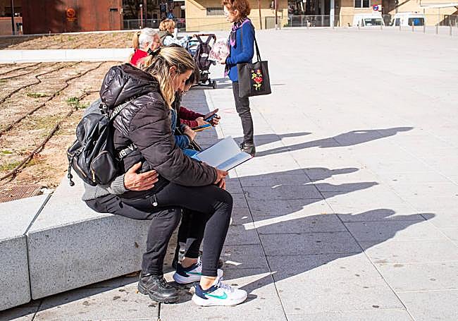 Paqui y Antonio, leyendo uno de los libros liberados en el exterior del hospital.