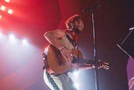 Manuel Carrasco interpretando una canción durante un concierto.