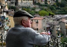 Una persona mayor, asomada a un mirador.