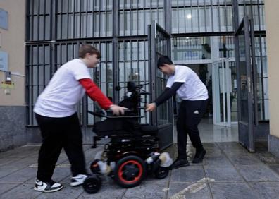 Imagen secundaria 1 - Arriba, Martín delante de su regalo. Abajo, acarreando la silla y una alumna con el peluche mascota. 