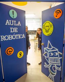 Imagen secundaria 2 - Arriba, monitores de ESO enseñan a los pequeños de Infantil a dar órdenes a un robot basándose en el pensamiento computacional. Abajo, Saul Velázquez explica el funcionamiento de su bot a una compañera y dos alumnas abren las puertas al aula de robótica. 