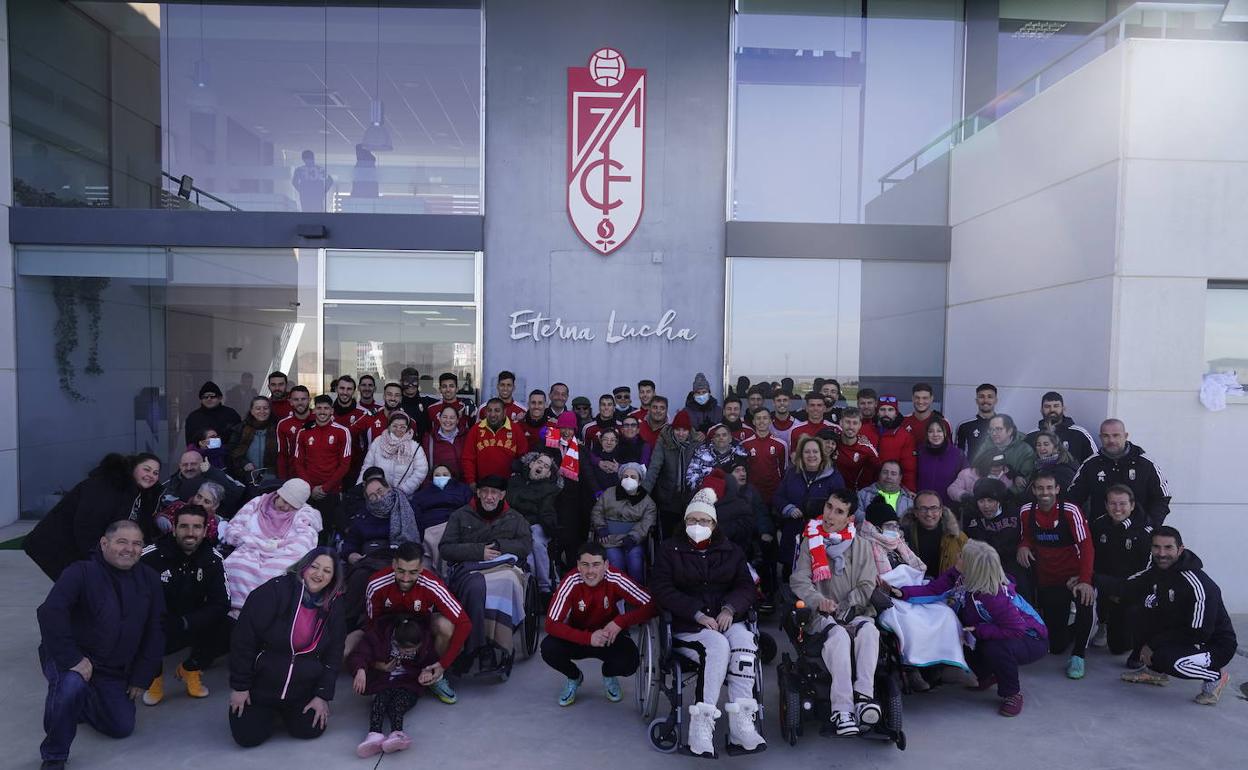 Foto de familia de los miembros de Aspace con futbolistas, y miembros del cuerpo técnico. 