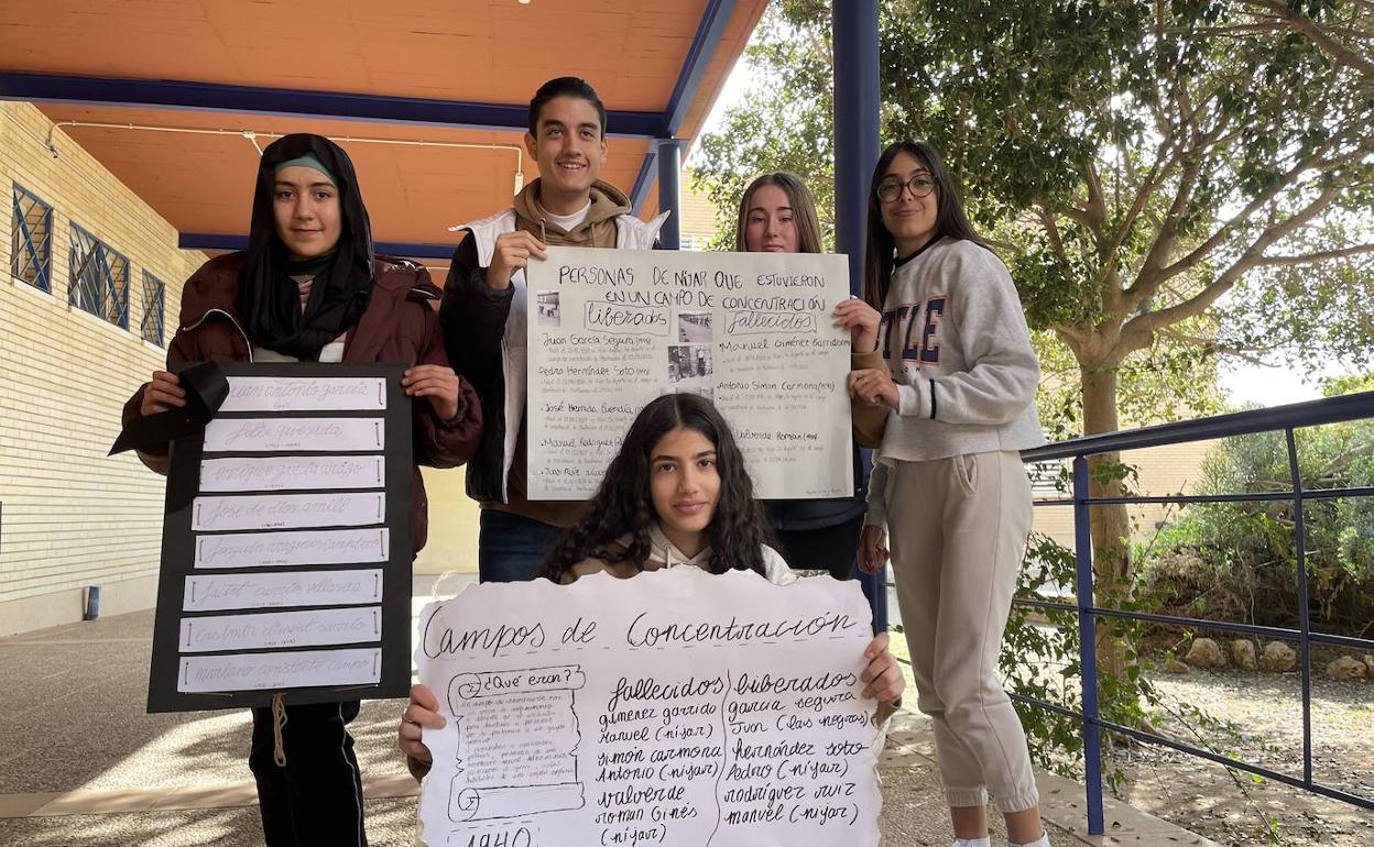 Los alumnos que llevan a cabo la investigación, en el centro, sosteniendo carteles alusivos. 