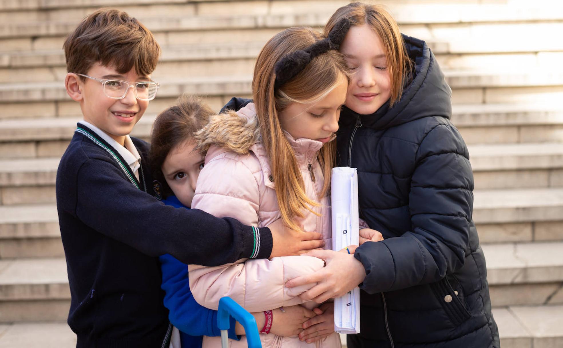 Nacho, Valentina y María abrazan a Polina (con abrigo rosa), ayer jueves, último día previsto de colegio en Granada antes de su traslado a una localidad de Jaén.