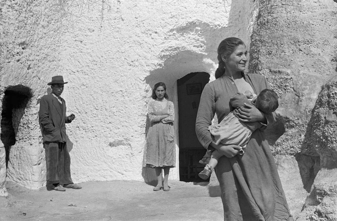 Loreto Amador, sonriente, amamantando al pequeño Frasco en Purullena ante la mirada de Antonio 'el Corbito' y María 'la Latera'. 